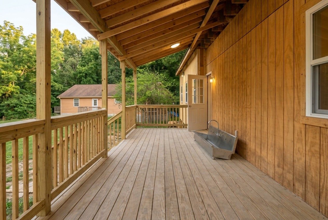 Covered wooden porch on a camp bunkhouse with a stainless steel wash sink